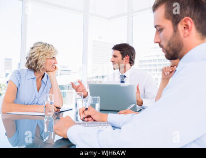 Intelligent junge Führungskräfte sitzen um besprechungstisch im Büro angezogen Stockfoto