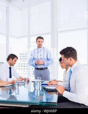 Intelligent junge Führungskräfte sitzen um besprechungstisch im Büro angezogen Stockfoto