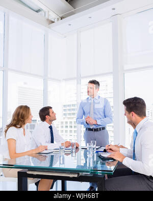 Intelligent junge Führungskräfte sitzen um besprechungstisch im Büro angezogen Stockfoto