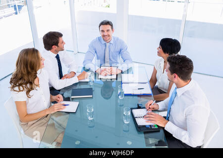 Intelligent junge Führungskräfte sitzen um besprechungstisch im Büro angezogen Stockfoto