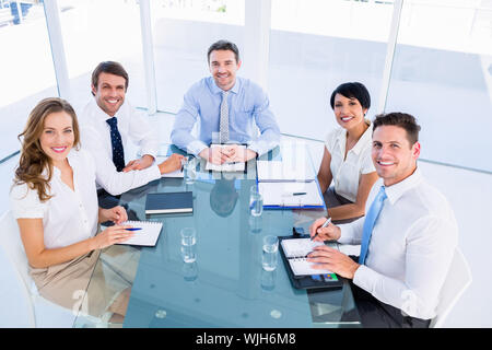 Intelligent junge Führungskräfte sitzen um besprechungstisch im Büro angezogen Stockfoto