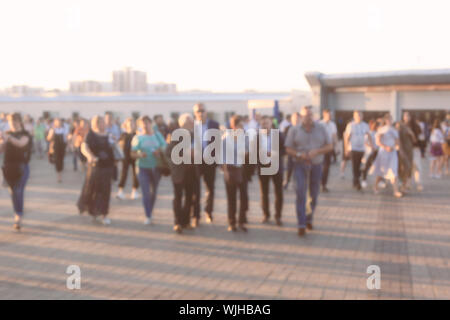 Masse von Menschen zu Fuß auf der viel befahrenen Straße der Stadt. Blured Stockfoto