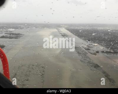 Marsh Harbour, Abaco, Bahamas. 02. September 2019. Eine US Coast Guard Jayhawk Rettungshubschrauber Erhebungen den überschwemmten Leonard M. Thompson International Airport, da es Ansätze zu landen im Gefolge des Hurrikans Dorian September 2, 2019 in Marsh Harbour, Abaco, Bahamas zu unterstützen. Dorian schlug die kleine Insel Nation als Kategorie 5 Sturm mit Windgeschwindigkeiten von 185 km/h. Quelle: Hunter Medley/USCG/Alamy leben Nachrichten Stockfoto