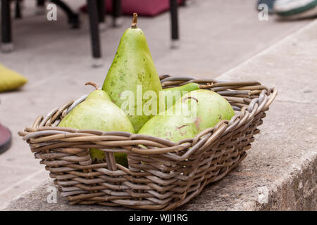 Frische reife Birnen in einem Weidenkorb Stockfoto