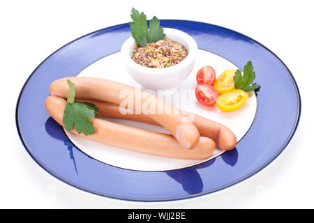 Drei kalt geräucherte Würstchen oder Wiener Würstchen serviert auf einem Teller mit einem Sprung in eine kleine Schüssel geben und in Scheiben geschnittenen Kirschtomaten auf ein weißes Studio-Hintergrund Stockfoto