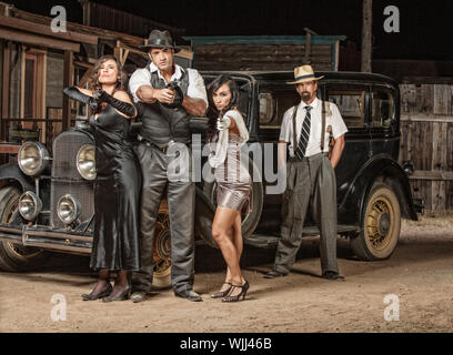 Gefährliche 1920er Jahre Vintage Gangster außerhalb mit Waffen Stockfoto