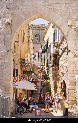 BARI, ITALIEN - Juli 11, 2018, Blick auf eine schmale Straße in Bari, Apulien, Italien, Bari Vecchia, traditionellen offenen Markt Geschäfte mit Souvenirs für Touristen Stockfoto