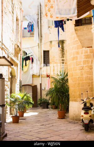 BARI, ITALIEN - Juli 11, 2018, Blick auf eine schmale Straße in der italienischen Stadt Bari, Bettwäsche ist in der Straße, getrocknet Stockfoto
