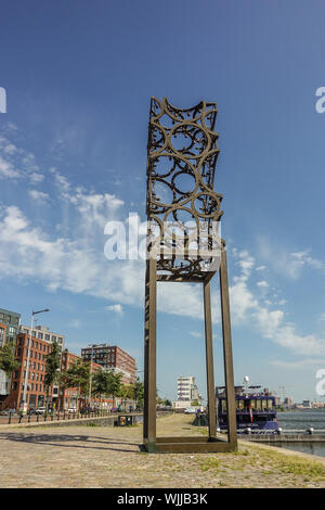 Amsterdam, Niederlande - 30. Juni 2019: Tall verrostete Kunstwerke, Skulpturen aus Metall Kreise miteinander verschweißt und gegen den blauen Himmel mit einigen weissen c Stockfoto