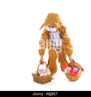 Kind verkleidet als Ostern Hase mit Korb Eiern und Blumen isoliert auf weißem Hintergrund Stockfoto