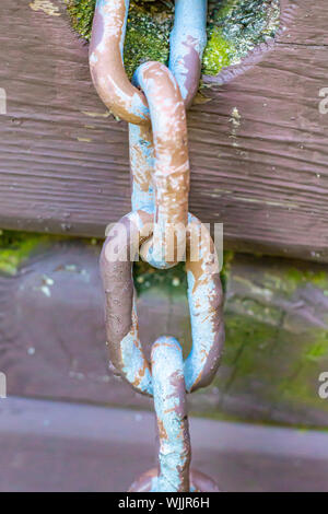 Glieder einer Kette angebracht zu einem hölzernen Struktur werden aus der Nähe gesehen. Stockfoto