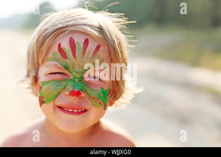 junge Kind mit einem bemalten Maske auf ihr Gesicht Stockfoto