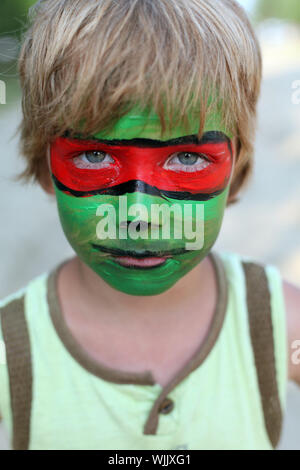 junge Kind mit einem bemalten Maske auf ihr Gesicht Stockfoto