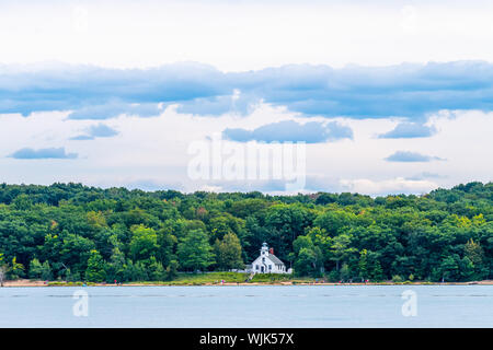 Menschen gehen am Strand vor der alten Mission Point Leuchtturm auf Old Mission Peninsula in der Nähe von Traverse City, Michigan, als vom Wasser aus gesehen. Stockfoto