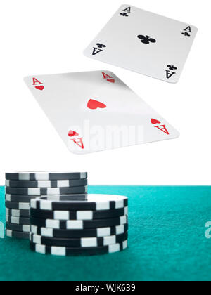 Zwei Asse fliegen über einen Stapel Chips auf dem Pokertisch. Stockfoto