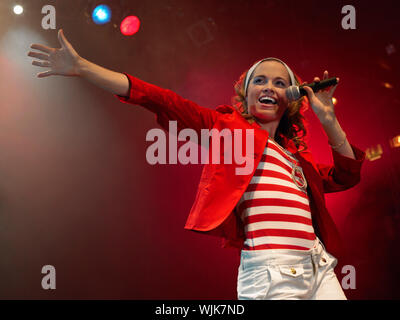 Low Angle Blick auf eine schöne junge Frau singen Sie in das Mikrofon auf der Bühne Stockfoto