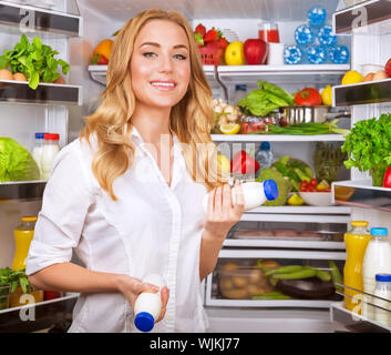 Joghurt in gewählt Frau öffnete Kühlschrank, coole neue Friedge voller leckere Bio Ernährung, frisches Obst und Gemüse, gesunde Ernährung Konzept Stockfoto