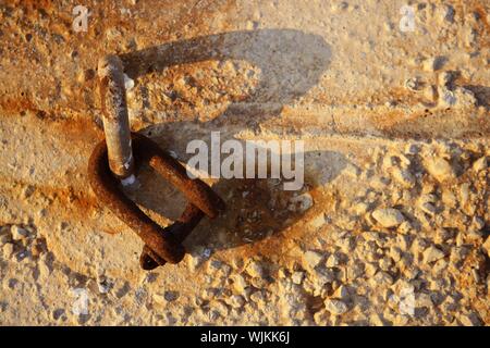 alte verrostete Schäkel auf der Hafen Betonsteine, goldene Abendlicht Stockfoto