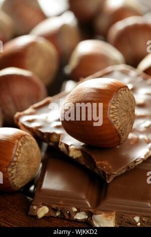 Haselnüsse und Schokolade auf braunen Holz Umwelt im studio Stockfoto