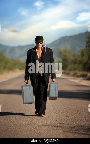 Seltsame indigenen Mann in der Mitte einer Straße mit Koffer Stockfoto