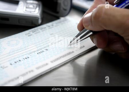 Firmar un Scheck. Melden Sie einen Bankscheck Stockfoto