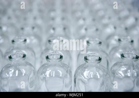 Transparente leere Glasflaschen in Reihen, Kosmetik-Fließband Stockfoto