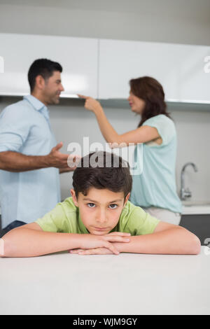 Closeup Portrait eines traurigen Sohn während die Eltern in der Küche Streit Stockfoto