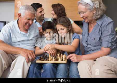 Glückliche Großfamilie Schach spielen auf dem Sofa im Wohnzimmer zu Hause. Stockfoto