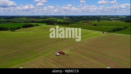 Luftaufnahme von Massey Ferguson 1880 Traktor ziehen Ladewagen, mit Claas Jaguar 940 Feldhäcksler auf Farm Luzerne Feld Monroe, Wisconsin, USA Stockfoto