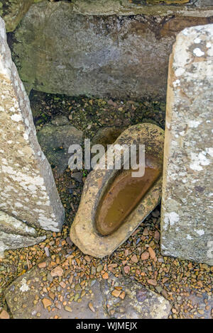 Broch von Gruness Innenraum mit Steinplatten und einem glatten Felsen geschnitzt, Wasser, Orkney, Schottland Stockfoto