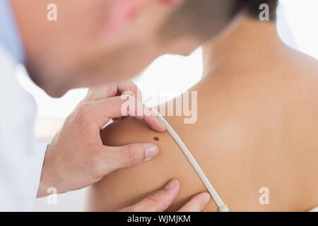 Männlicher Arzt untersuchen Mole auf der Rückseite der Frau in der Klinik Stockfoto