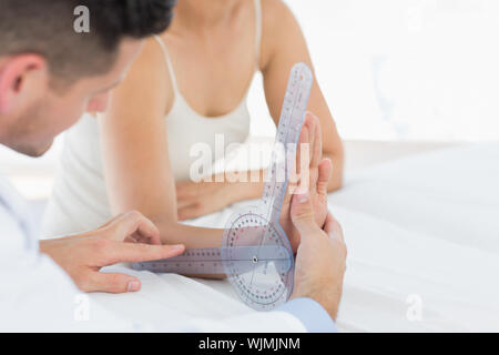 Physiotherapeut untersuchen Patienten Handgelenk mit goniometer in Klinik Stockfoto