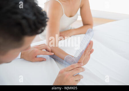 Physiotherapeut untersuchen Patienten Handgelenk mit goniometer im Büro Stockfoto