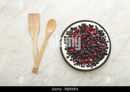 Berry pie mit frischen Beeren und Sahne auf murble Tabelle mit Kirsche, Johannisbeere, Brombeere, Heidelbeere. Käsekuchen, Ansicht von oben mit der Kopie. Stockfoto