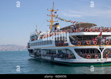 In Istanbul, die Fähre am Meer war von der Seebrücke. Aufnahme von hinten. Menschen in Steamboat. Stockfoto