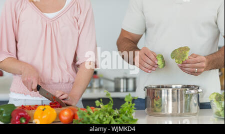 Mittelteil der Paare essen zusammen Vorbereiten auf den Küchentisch Stockfoto