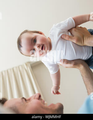 Low Angle View von adorable Baby boy von Vater zu Hause durchgeführt werden Stockfoto