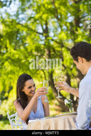 Lächelnde junge Paar toasten Champagnergläser an einer im Café &#xc3; &#xa9; Stockfoto