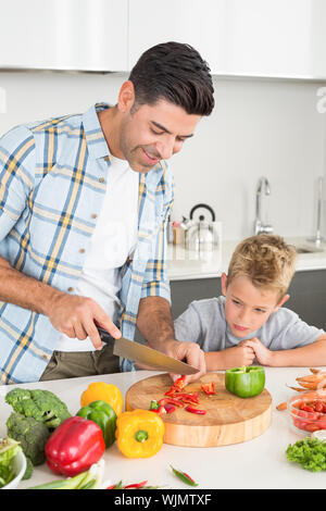 Stattliche Vater Lehre, sein Sohn, wie Gemüse zu Hause in der Küche zum Häckseln Stockfoto