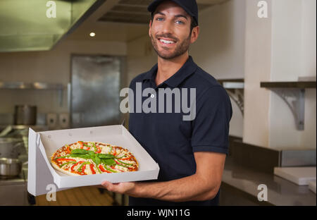 Happy Pizza Delivery Man, frische Pizza in einem kommerziellen Küche Stockfoto