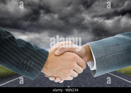 Das zusammengesetzte Bild im Business Handshake gegen stürmische Landschaft Hintergrund mit street Stockfoto