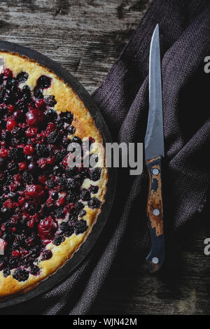 Berry pie mit Kirsche, Johannisbeere, Brombeere, Heidelbeere auf Holztisch im rustikalen Stil. Käsekuchen, Ansicht von oben. Stockfoto