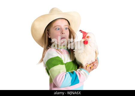 Lustige Kinder Mädchen Ausdruck überrascht Geste erschrocken über Henne auf weißem Hintergrund Stockfoto