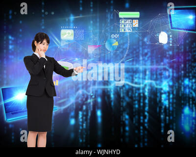 Geschäftsfrau, die gegen leuchtende blaue Taste auf schwarzem Hintergrund Stockfoto