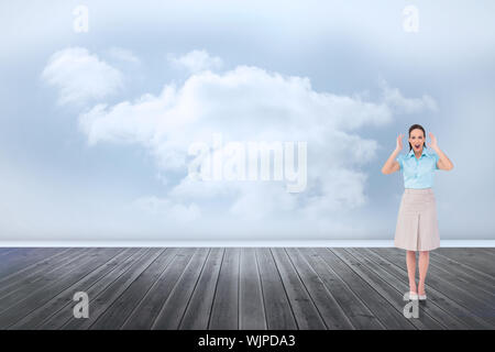 Überrascht stilvolle Geschäftsfrau gegen Wolken in einem Zimmer posing Stockfoto