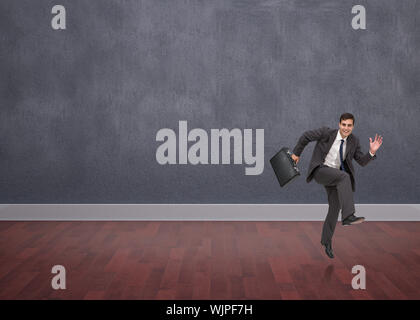 Happy Geschäftsmann in einem hury gegen Zimmer mit Holzboden Stockfoto