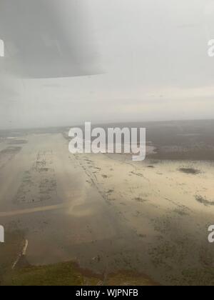 Marsh Harbour, Abaco, Bahamas. 03. September 2019. Eine US Coast Guard Jayhawk Rettungshubschrauber Erhebungen den überschwemmten Leonard M. Thompson International Airport, da es Ansätze zu landen im Gefolge des Hurrikans Dorian September 3, 2019 in Marsh Harbour, Abaco, Bahamas zu unterstützen. Dorian schlug die kleine Insel Nation als Kategorie 5 Sturm mit Windgeschwindigkeiten von 185 km/h. Quelle: Hunter Medley/USCG/Alamy leben Nachrichten Stockfoto