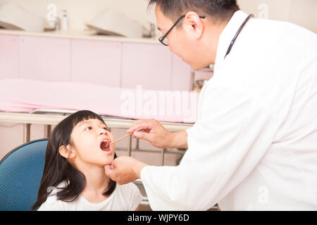 Kinderarzt Kind Kehle mit Zunge Depressor Prüfung Stockfoto
