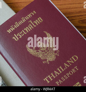 Thai Pass mit Notebook auf Holztisch Hintergrund Stockfoto