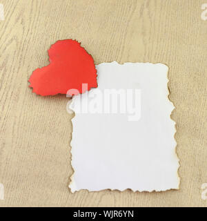 Herz und weißes Papier auf Holz Hintergrund Stockfoto